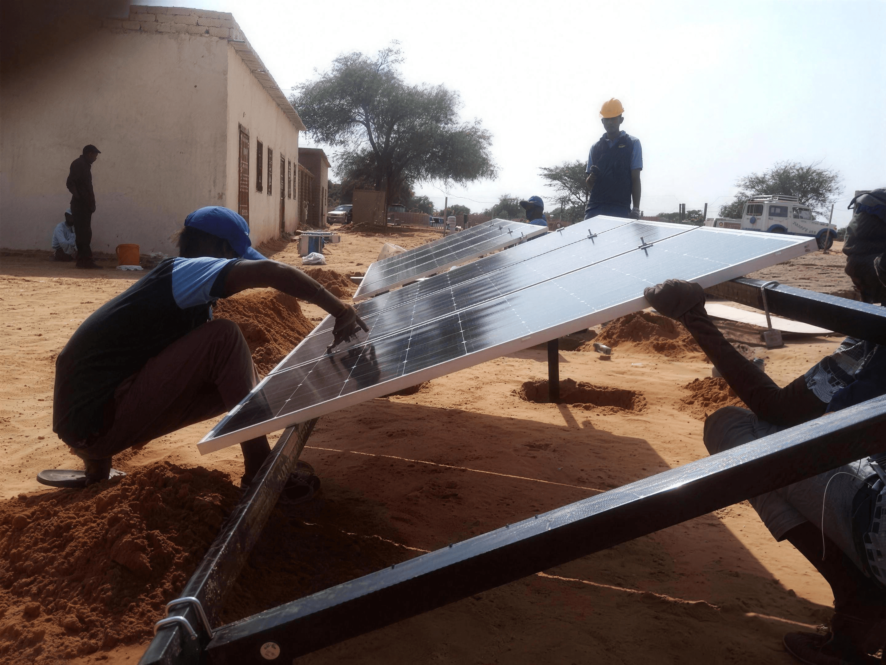 Saruest installers assembling a ground-mounted solar array in a Sudanese village